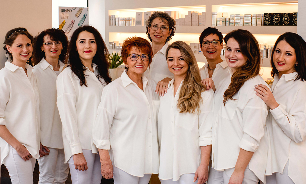 Zwei Frauen, eine lehnt den Kopf an die andere, beide schauen frontal.